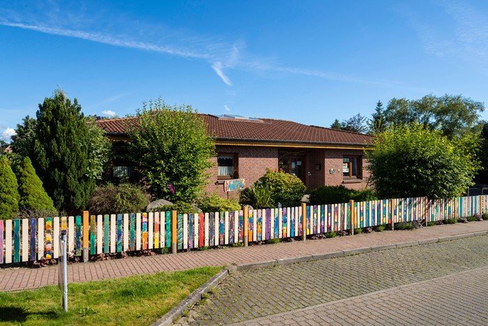 Kirchenkindergarten-Gebäude mit buntem Zaun.