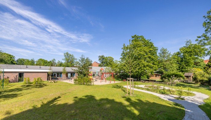 Kitawerk-Gebäude mit Solaranlage, grüner Bereich.