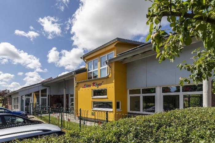 Helles Kirchenkindergarten-Gebäude an sonnigem Tag.