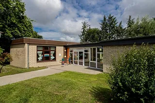 Kirchenkindergarten mit großen Fenstern, heller Tag.