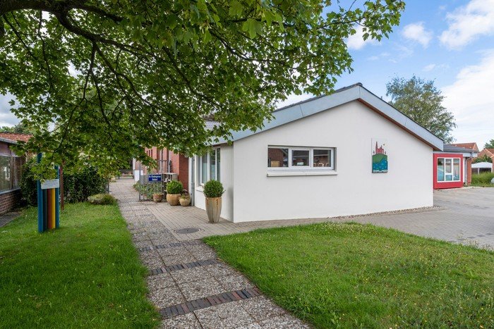 Kirchenkindergarten mit weißer Fassade und Rasenfläche.