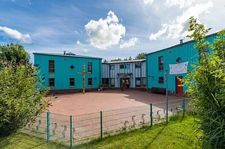 Modernes Kitawerk mit Kreuz und zentralem Platz.