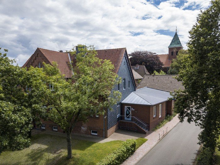 Dorfansicht mit Kirchturm und Häusern.