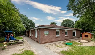 Kirchenkindergarten mit Rutsche und Sandkasten.